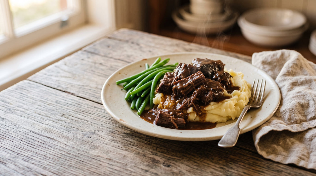 Slow cooker beef and gravy made with grass-fed blade steak, served over creamy mash with steamed greens.